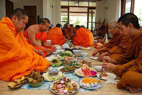Thai monks eating together at a house blessing